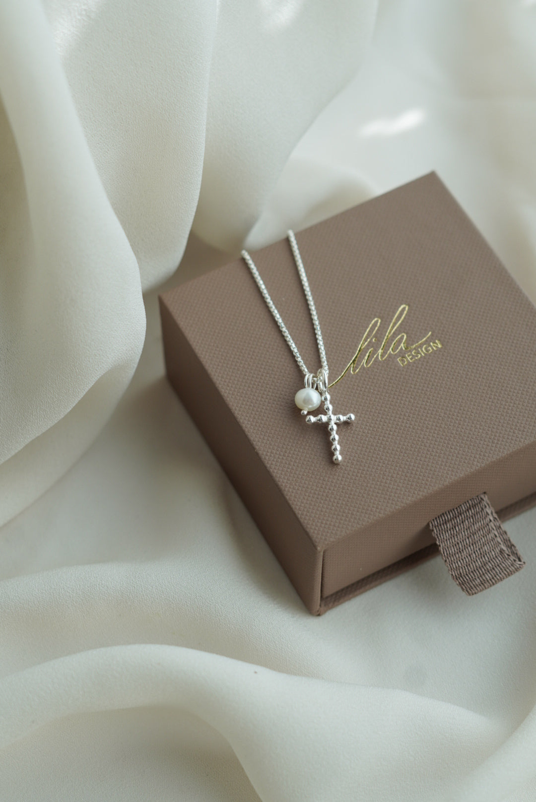 ristikaulakoruhelmellä_kaunis risti koru_kotimainen rippiristi_hopeinen risti_hopea rippiristi ja helmi_valkoinen helmi ja risti