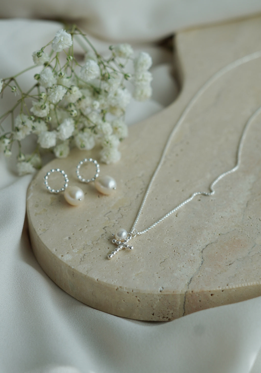 kotimainen rippiristi helmellä_valkoinen helmi ja risti_hopeinan risti helmellä_bubbel risti